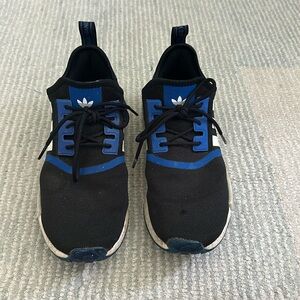 Black, blue, and white Adidas NMD’s